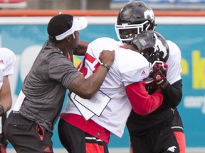 A dust-up between Tommie Campbell and Osagie Odiase (R) is quickly broken up by defensive backs coach Kahlil Carter and teammates during the Calgary Stampeders training camp at McMahon Stadium in Calgary, Alta., on Wednesday, June 8, 2016. The regular season begins on June 25, when the Stamps head to B.C. Lyle Aspinall/Postmedia Network