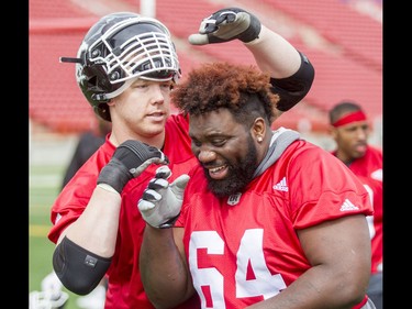 Dan Federkeil has a go at Derek Dennis's hair during the Calgary Stampeders training camp at McMahon Stadium in Calgary, Alta., on Thursday, June 2, 2016. The regular season begins on June 25, when the Stamps head to B.C. Lyle Aspinall/Postmedia Network