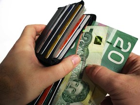 The action of pulling canadian money out of a wallet.