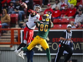 Edmonton Eskimos' Bryant Mitchell, right, looks on as Calgary Stampeders' Tommie Campbell swats away the ball during first half CFL pre-season football action in Calgary, Saturday, June 11, 2016.THE CANADIAN PRESS/Jeff McIntosh ORG XMIT: JMC104