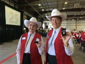 White Hat volunteers Vivian Crandall, left, and Bev Niven, holding the pins they received for their 25 years volunteering at the Calgary airport. Four volunteers were recognized for being with the program since it launched in 1991.