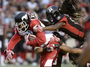 Ottawa Redblacks' Abdul Kanneh (14) tries to strip Calgary Stampeders' Bakari Grant (81) of the ball during the first half of a CFL football game in Ottawa on Friday, July 8, 2016.