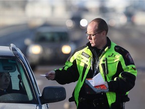 Const. Dan Kurz of the Calgary Police Traffic Section issues a motorist a speeding ticket.