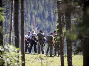 Alberta Fish and Wildlife and RCMP chat near Trapper's Hill Lodges northeast of Cochrane, Alta., on Tuesday, July 19, 2016. A woman suffered non-life-threatening injuries when she was attacked by a grizzly bear while resting on a river bank with her husband. Lyle Aspinall/Postmedia Network