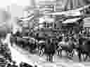 An eight-span bull team wends its way through downtown in 1912 as part of the very first Calgary Stampede parade. 