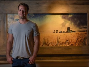 Brad Holt poses in front of one of his artworks inside the Western Oasis at the 2016 Calgary Stampede in Calgary, Alta., on Monday, July 11, 2016.  Holt paints and crafts the frames for his artwork from reclaimed wood. Elizabeth Cameron/Postmedia