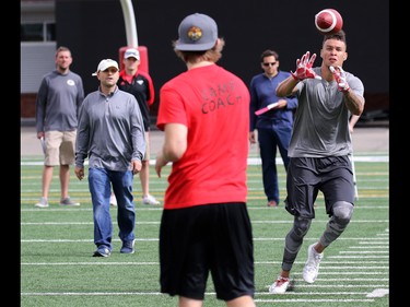 Jordan Heather throws balls for University of Calgary Dinos wide receiver Rashaun Simonise while Simonise is watched by six NFL scouts at McMahon Stadium in Calgary on Monday July 11, 2016. Simonise has been declared eligible for the NFL supplementary draft.