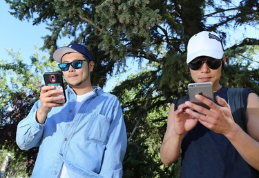 Jin Choi, left and Josh Jang play Pokemon Go on Prince's Island in Calgary over the lunch hour on Tuesday July 19, 2016. 
Gavin Young/Postmedia