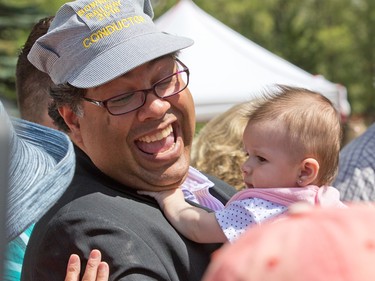 Calgary Mayor Naheed Nenshi holds three month-old Davida Muldowney while attending the first official run of the Bowness Park miniature train on Thursday July 28, 2016.