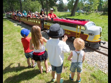 From left, Felix Moreno, 3, Cosette Swart, 5,  Iago Moreno, 6, and Lewis Swart, 2 wave to the Bowness Park miniature train Calgary on its' first day back in service, Thursday July 28, 2016. The train was destroyed in the 2013 floods and had to be completely restored by a team from the Call of the West Museum in High River.