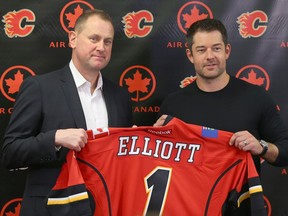 Calgary Flames GM Brad Treliving (L) poses with goaltender Brian Elliott as the new player is introduced to media in Calgary, Alta. on Wednesday July 27, 2016. Jim Wells/Postmedia