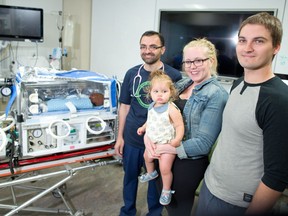 One year-old Tegan de Vries with her parents Katie Kaminski and Curtis de Vries and neonatologist Dr. Khorshid Mohammad at the Alberta Children's Hospital in Calgary on July 25, 2016. Tegan was helped by a cooling device when she was born having difficulty breathing last year. The device induces therapeutic hypothermia to help prevent brain damage and promote healing.