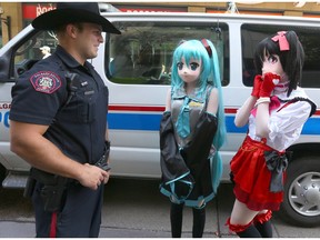 Calgary police Cst. Rick Toth chats with anime characters during Otafest in downtown Calgary on July 2, 2016.