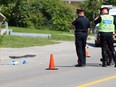Police investigate the scene where a pedestrian was hit and badly injured by a driver reversing an SUV on Hawkwood Drive near Hawkwood Boulevard N.W. in Calgary on Thursday July 28, 2016.