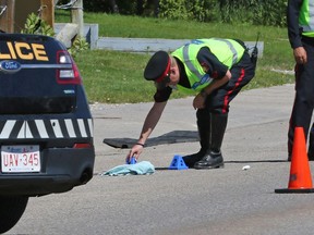 Police investigate the scene where a pedestrian was hit and badly injured by a driver reversing an SUV on Hawkwood Drive near Hawkwood Boulevard N.W. in Calgary on Thursday July 28, 2016.