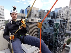 Postmedia's Lyle Aspinall rappels 15 stories from Barclay Centre in downtown Calgary to raise awareness for the Make-A-Wish Southern Alberta's Rope for Hope fundraiser on Wednesday July 6, 2016. 70 people will rappel from the building on Thursday.  Gavin Young/Postmedia