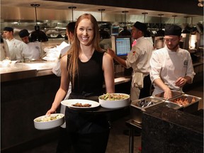 Servers work during the busy lunch hour at the Earls.67 restaurant in downtown Calgary on Monday July 11, 2016. Instead of the traditional tipping method the rebranded location is testing a new 16 percent hospitality charge to all bills. Gavin Young/Postmedia