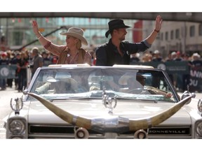 Calgary Stampede Parade marshals Jann Arden and Paul Brandt wave to the crowd during the parade in Calgary, Alta., on Friday July 8, 2016. Leah Hennel/Postmedia