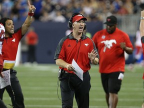 Calgary Stampeders head coach Dave Dickenson applauds a interception return for a touchdown during CFL action against the Blue Bombers in Winnipeg on Thu., July 21, 2016. Kevin King/Winnipeg Sun/Postmedia Network