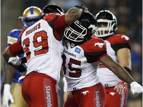 Calgary Stampeders' Ja'Gared Davis (95) and Charleston Hughes (39) celebrate Davis' sack on Winnipeg Blue Bombers quarterback Matt Nichols (15) during the second half of CFL action in Winnipeg Thursday, July 21, 2016.