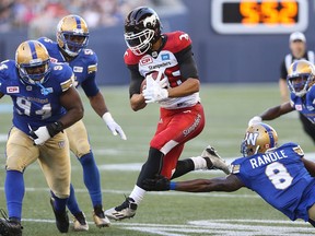 Calgary Stampeders receiver Anthony Parker jumps between Winnipeg Blue Bombers DL Euclid Cummings (left) and DB Chris Randle during CFL action in Winnipeg on Thu., July 21, 2016. Kevin King/Winnipeg Sun/Postmedia Network