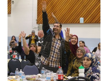 Syrian refugees raise their hands excitedly as an emcee asks people to name 5 Canadian cities during the iftar, the breaking of the fast, Tuesday evening June 28, 2016 at Marlborough Community Centre. The Syrian refugee community gathered to celebrate the end of their first Ramadan in Calgary.