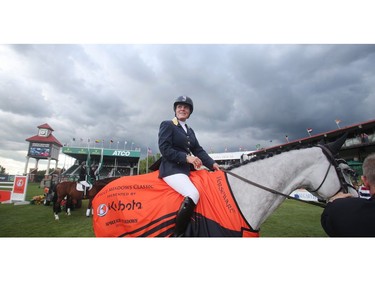 An Alberta storm looms overherad as Leslie Howard of the USA sits atop Donna Speciale in the winner's circle following her victory in the Spruce Meadows Classic, the final event of  the North American Sunday July 10, 2016.