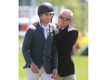 Calgary's Chris Surbey is congratulated by Spruce Meadows Competitions Manager Jon Garner as he walks to the trophy presentation after riding Quetchup de la Roque to victory in the Enbridge Classic Derby during the North American Sunday July 10, 2016.