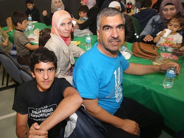 Syrian refugees, Ahmed Shako, left, and his parents Mohammad and  Ghada during the iftar, the breaking of the fast, as Syrian refugees celebrate their first Ramadan in Calgary Tuesday evening June 28, 2016 at Marlborough Community Association.