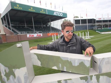 Oliver Morin of Montreal, part of the jump crew, sets up the Normandy Wall jump Tuesday July 5, 2016 prior to the Wednesday start of the Spruce Meadows North American.