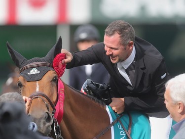 Eric Lamaze and Rosana Du Park receive the ribbon after winning the ATCO Energy competition at the Spruce Meadows North American Wednesday afternoon July 6, 2016.
