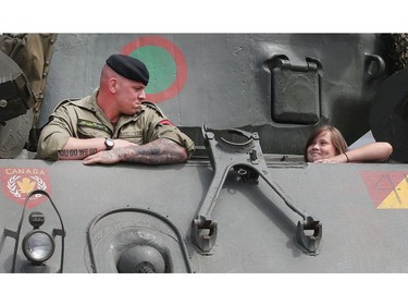Master Corporal Seamus Bondy of the Lord Strathcona's Horse Royal Canadians chats with 10 year old Lea Grenier from Ottawa inside a Sherman tank at Spruce Meadows during the North American Friday July 8, 2016. The tank was one of the pieces of equipment being shown by the regiment's Historical Vehicle Troop.