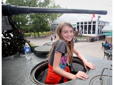 Kelly Anne Busque of Calgary pops her head out of the hatch of the Sherman tank on display with the Lord Strathcona's Horse Royal Canadians at Spruce Meadows during the North American Friday July 8, 2016. The tank was one of the pieces of equipment being shown by the regiment's Historical Vehicle Troop.