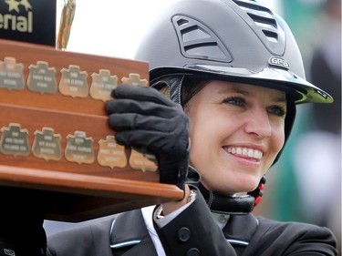 Canadian Tiffany Foster is all smiles as she accepts the Imperial trophy after winning on her horse Brighton Saturday July 9, 2016 during the Spruce Meadows North American.