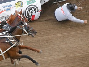 Chuckwagon driver Rick Fraser flies from his seat as his wagon flips over at the start of Heat 4 of the Rangeland Derby chuckwagon races at the Calgary Stampede on Sunday July 10, 2016. It was announced after the incident that neither Rick Fraser nor any of the horses were hurt.