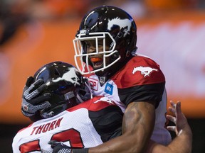Calgary Stampeders' Bakari Grant, right, and Cam Thorn celebrate Grant's touchdown against the B.C. Lions during the second half of a pre-season CFL football game in Vancouver, B.C., on Friday June 17, 2016.