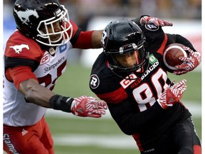 Ottawa Redblacks' Chris Williams (80) runs the ball against Calgary Stampeders' Tommie Campbell (25) during the first half of a CFL football game in Ottawa on Friday, July 8, 2016.