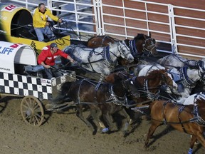Crystal Schick/ Postmedia CALGARY, AB -- Kirk Sutherland, yellow, challenges Jason Glass, red, from behind to tie him at the finish line in heat nine on day seven of Calgary Stampede's GMC Rangeland Derby, on July 14, 2016. Sutherland won the heat after Glass received a two second penalty. --  (Crystal Schick/Postmedia) (For  story by  )