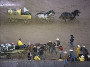 Gary Gorst watches as Kirk Sutherland passes him  and his fallen team at the start/finish line in first place in heat nine on day nine of Calgary Stampede's GMC Rangeland Derby, on July 16, 2016.