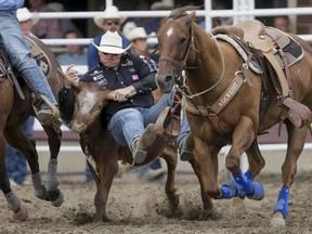 Dakota Eldridge of Elko, Nev., puts in the best steer-wrestling time of Day 5 of the Calgary Stampede Rodeo in Calgary, Alta., on Tuesday, July 12, 2016. Cowboys compete for 10 days for a piece of the rodeo's $2 million in prize money. Lyle Aspinall/Postmedia Network