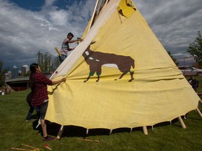 Family and friends set up the teepee of Leo Pretty Young Man of the Siksika Nation at the new Indian Village at Stampede Park in Calgary, Ab., on Sunday July 3, 2016. Mike Drew/Postmedia