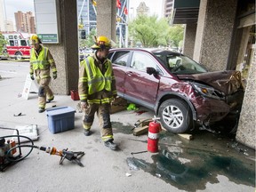 Firemen work after a crash at the corner of 4 Ave and Centre St S in downtown Calgary on Tuesday, July 5, 2016.