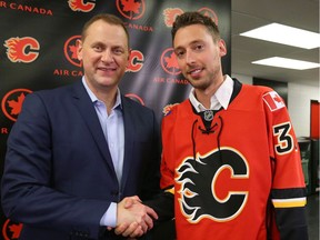 Flames Brad Treliving shakes hands with newly acquired Chad Johnson in Calgary, Alta on Friday July 1, 2016.
