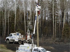ATCO Electric workers repair power lines damaged by wildifre near Fort McMurray, Alberta on May 9, 2016.