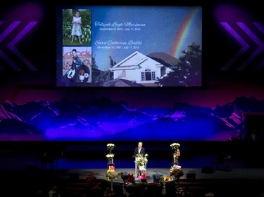 A pair of rainbows shows over a home pictured in an overhead projection as Rev. Miriam Mollering speaks during a memorial service for Sara Baillie and Baillie's five-year-old daughter Taliyah Marsman at Centre Street Church in Calgary.