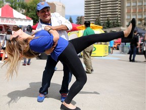 Hector Menjivar dips his daughter Cindy Sosa during Fiestaval Latina this weekend in Calgary. The family has their food booth La Casa Latina set up at Olympic plaza for the festival.