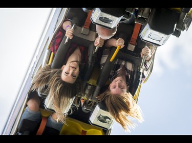 Emily Beaton (L) and Taylor McGee ride the Fire Ball on the midway during the Calgary Stampede Sneak-a-Peek in Calgary, Alta., on Thursday, July 7, 2016. Stampede would officially kick off the next day and last until July 17. Lyle Aspinall/Postmedia Network