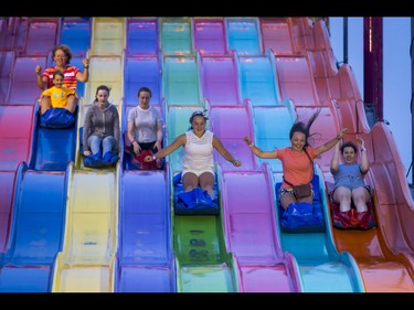 People cruise down the Euro Slide on the midway during the Calgary Stampede Sneak-a-Peek in Calgary, Alta., on Thursday, July 7, 2016. Stampede would officially kick off the next day and last until July 17. Lyle Aspinall/Postmedia Network