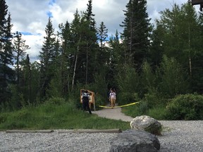 Hikers are escorted off Heart Creek Trail Sunday evening by RCMP officers.