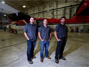 Kenn Borek Air pilot Wally Dobchuk, centre, co-pilot Sebastien Trudel, right, and maintenance engineer Mike McCrae, left, pose with the Twin Otter airplane they used in a successful medical evacuation of two sick researchers from the Amundsen-Scott station in the South Pole, in Calgary, Alta., Tuesday, July 5, 2016.